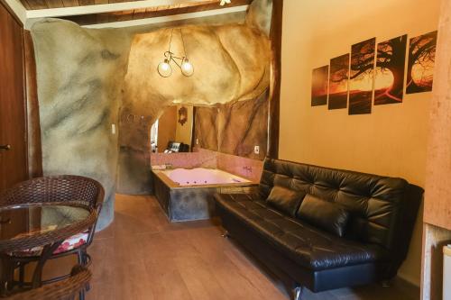 a living room with a couch and a bath tub at Pousada Cantagalo in Itaipava