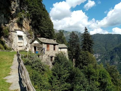 an old stone building on a mountain with a fence at Casa Rimasco in Rimasco