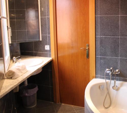 een badkamer met een wastafel, een bad en een toilet bij SENTIR VIC in Vic