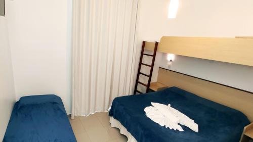 a bedroom with a bed with white feathers on it at Pousada Omnimare in Ubatuba