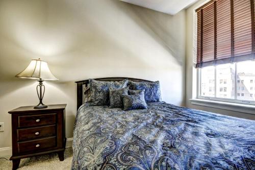 a bedroom with a bed and a lamp and a window at Harbor apartments Free indoor Parking in Baltimore