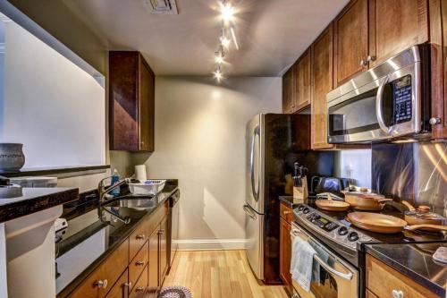 a kitchen with stainless steel appliances and wooden cabinets at Harbor apartments Free indoor Parking in Baltimore