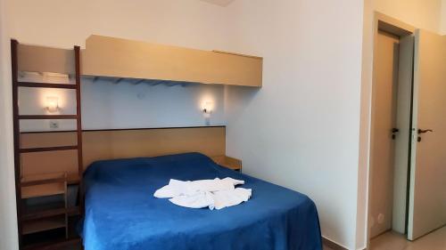 a bedroom with a bed with two white towels on it at Pousada Omnimare in Ubatuba