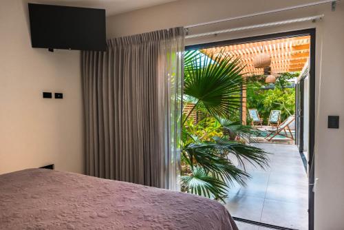 a bedroom with a large sliding glass door to a patio at Zen Garden Tamarindo - Adults Only in Tamarindo