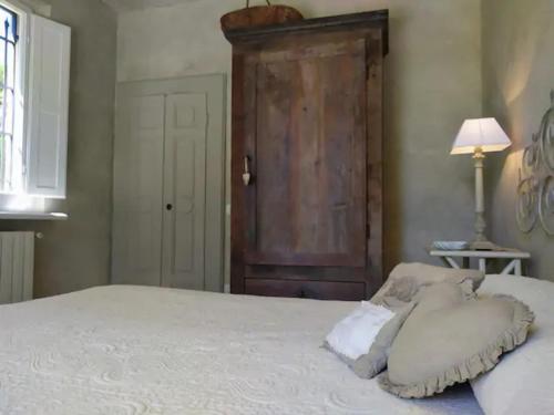 a bedroom with a white bed with a wooden door at B&B La Limonaia in Pietrasanta