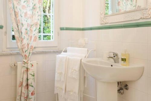 bagno bianco con lavandino e specchio di B&B La Limonaia a Pietrasanta