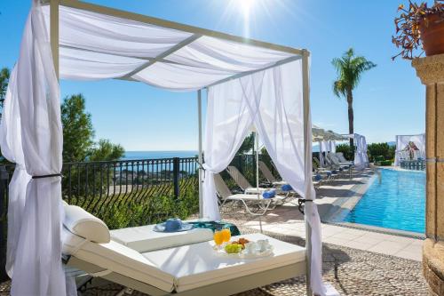 a canopy bed on a patio next to a pool at Pefkos View Suites & Maisonette in Pefki