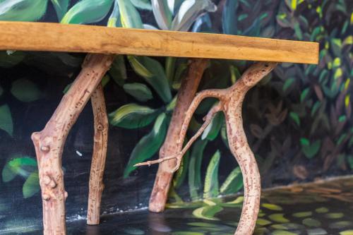 a wooden bench with rusted legs on a table at Latica Lodge in Playa Negra