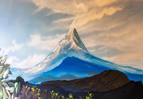 a painting of a mountain against a cloudy sky at Latica Lodge in Playa Negra
