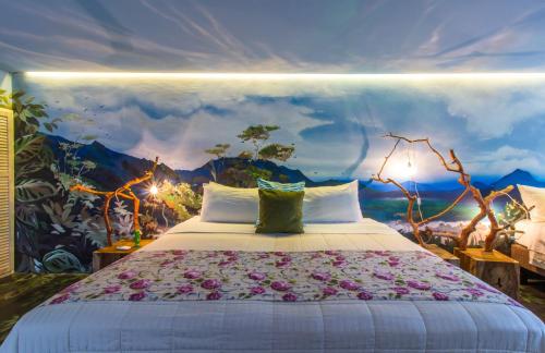 a bedroom with a large bed with a painting on the wall at Latica Lodge in Playa Negra