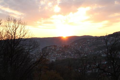 a sunset over a city in the mountains at Kucica u Šumi in Užice