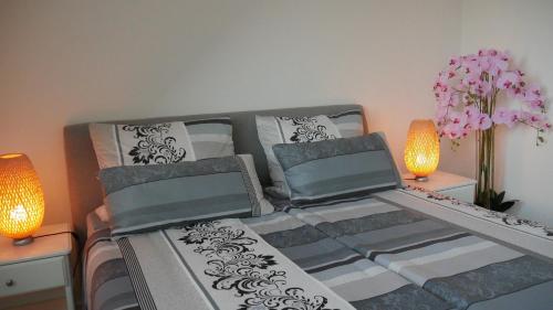 een slaapkamer met een bed met 2 lampen en bloemen bij Stadtnahe Komfortferienwohnung für Familien und Geschäftsreisende in Hildesheim