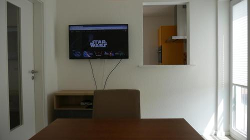 a living room with a tv on a wall at Stadtnahe Komfortferienwohnung für Familien und Geschäftsreisende in Hildesheim