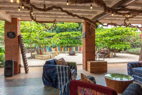 a living room with couches and a patio with trees at Latica Lodge in Playa Negra