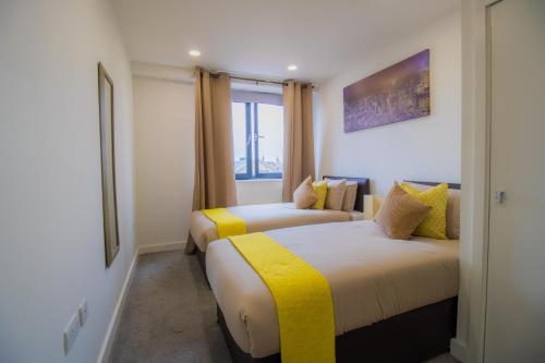 um quarto de hotel com duas camas e uma janela em Virexxa Bedford Centre - Alpha Suite - 2Bed Flat with Free Parking & Gym em Bedford