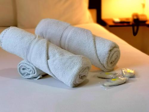 a roll of white toilet paper on a bed at Hotel Armonía Hostal in San Salvador