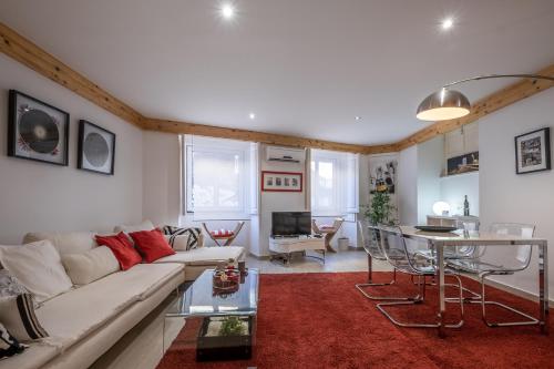 a living room with a white couch and a red rug at Lisbon City Center Baixa in Lisbon