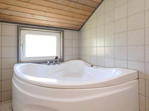 baño con bañera blanca y ventana en 10 person holiday home in L kken, en Lønstrup