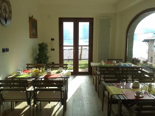 una sala da pranzo con tavoli e sedie in una stanza di Agriturismo Botton D'Oro a Dongo