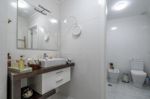 a white bathroom with a sink and a toilet at Lisbon City Center Baixa in Lisbon