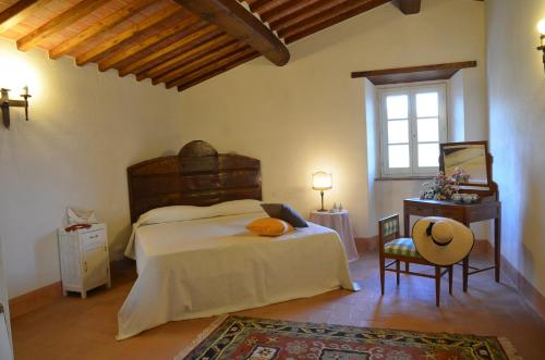 a bedroom with a bed and a chair and a window at Fonte Comelia in Cortona