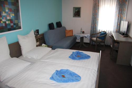 a bedroom with a bed with blue towels on it at Hotel am Schloss Neuenstein in Neuenstein