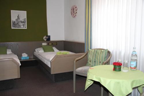 a bedroom with a bed and a table and chairs at Hotel am Schloss Neuenstein in Neuenstein