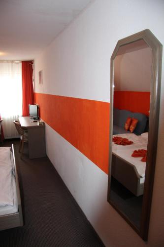 a room with a mirror and a bed and a desk at Hotel am Schloss Neuenstein in Neuenstein