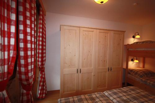 a bedroom with a bed and a cupboard and curtains at Landgasthof Kirchenwirt in Krimml