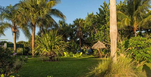 a yard with palm trees and a table and chairs at South Beach Place - Vero Beach in Vero Beach