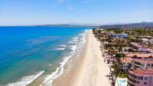 uma vista aérea de uma praia com palmeiras e do oceano em Bungalows Maria Teresa em Rincon de Guayabitos