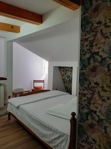 a bedroom with a large bed with a floral wallpaper at MON AMI in Sărata-Monteoru