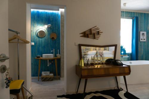 uma casa de banho com banheira e um quarto com paredes azuis em Casa da Almoinha em Unhais da Serra