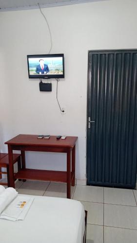 a room with a desk and a tv and a door at Hotel Rilton in Carolina