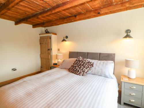 里士满Duck Cottage的带床和木质天花板的卧室