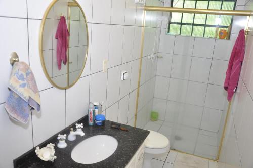 a bathroom with a sink and a toilet and a mirror at Chalé e Camping Daragona 1 in Águas de Lindóia