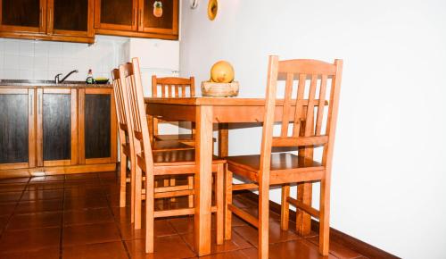 a kitchen with a wooden table and chairs at Quinta dos Frutos in Santa Cruz da Graciosa