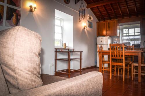 a living room with a couch and a kitchen at Quinta dos Frutos in Santa Cruz da Graciosa