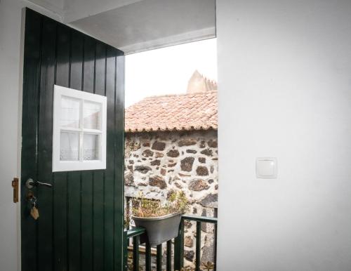 a door leading to a balcony with a chair at Quinta dos Frutos in Santa Cruz da Graciosa