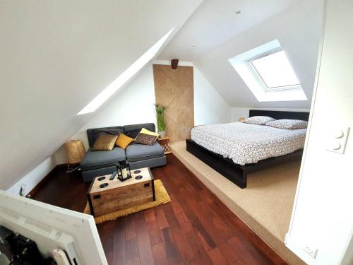 Schlafzimmer im Dachgeschoss mit einem Bett und einem Sofa in der Unterkunft Appartements Up & Down by Beds76 in Rouen
