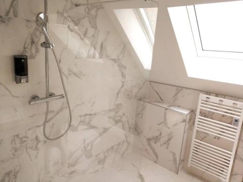 a bathroom with a shower with white marble at Appartements Up & Down by Beds76 in Rouen