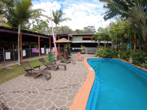 a resort with a swimming pool and chairs and a building at 1770 Southern Cross Travellers Retreat in Agnes Water