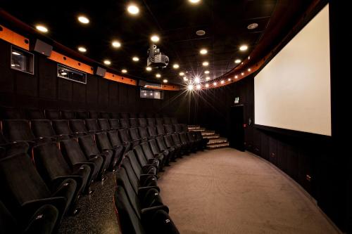 an auditorium with chairs and a white screen and lights at Hotel Paka in Velenje
