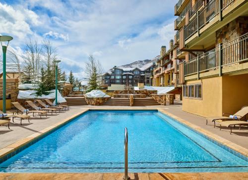 a pool at a hotel with chairs and a building at The Landmark in Vail