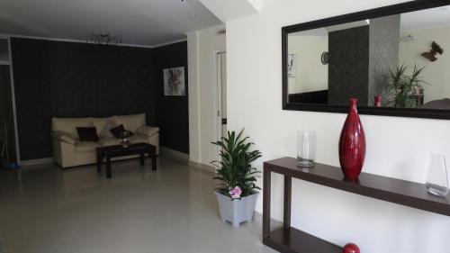 a living room with a couch and a mirror at Hotel Lido in Mar del Plata