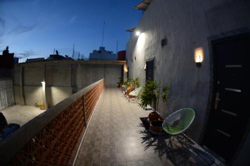 a balcony with chairs and plants on a building at La Maja Suites in Villahermosa
