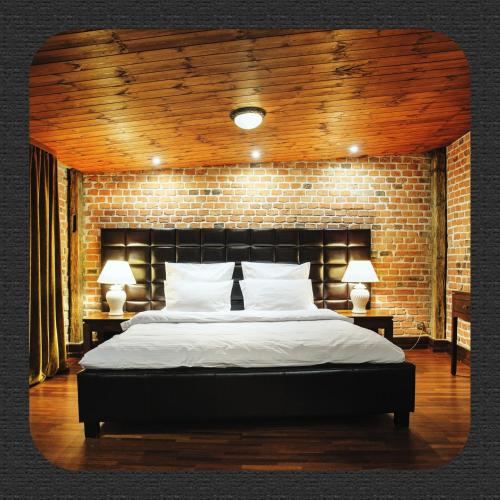 a bedroom with a large bed with a brick wall at Apartamenty Chleb i Wino Strumykowa in Toruń