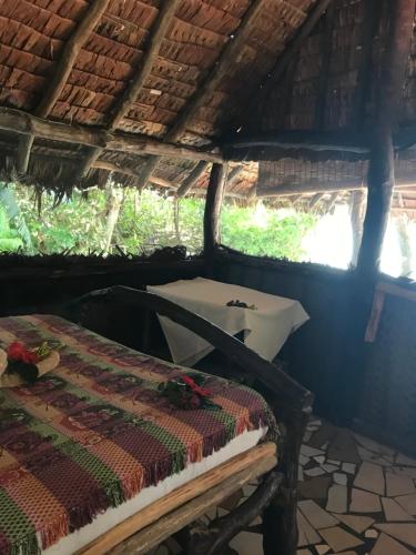 a room with a bed and a sink in a hut at Tranquility Island Eco Dive Resort in Moso Island