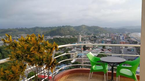 a balcony with a table and chairs and a city at Arco Iris Atacames in Atacames