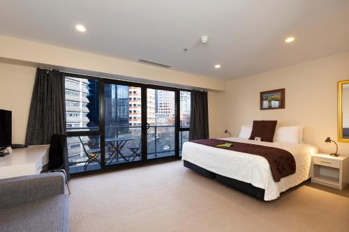 a bedroom with a large bed and a large window at The Chancellor on Hobson in Auckland